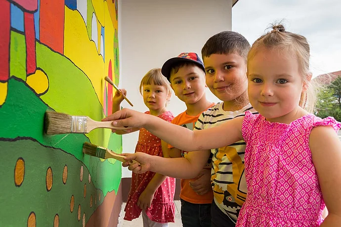 Kinder bemalen die Bushaltestelle Kinder bemalen die Bushaltestelle